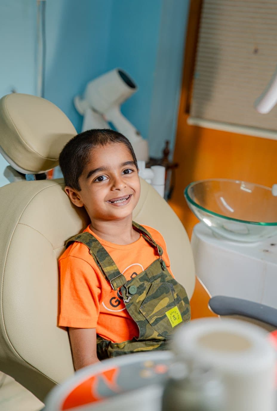 A young boy sitting happily in the dental chair after his check-up