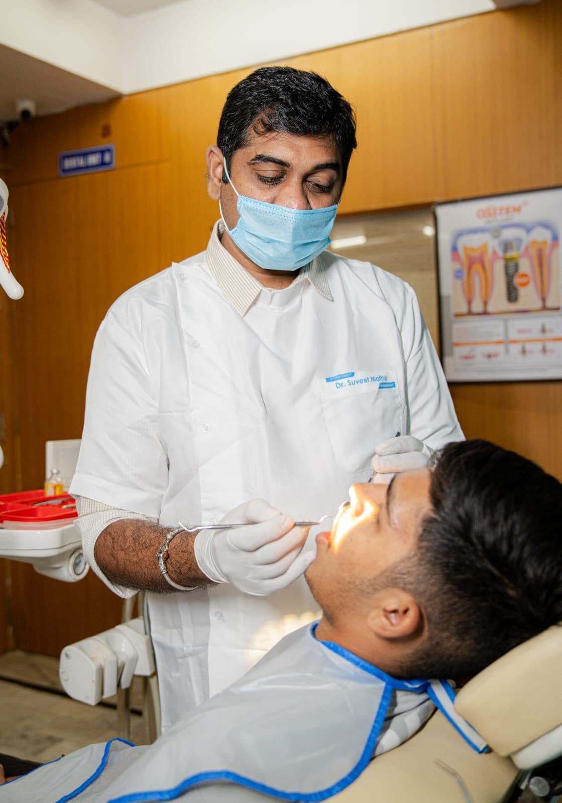 Dr Suveet Mathur examining an adult patient in the treatment chair
