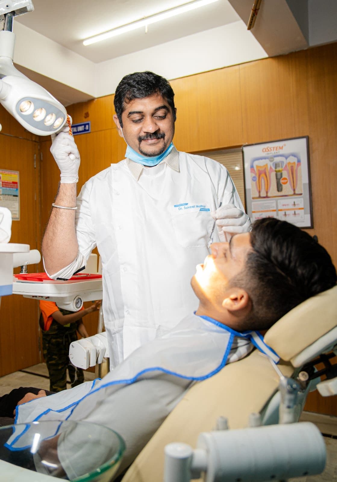 Dr Suveet Mathur adjusting the overhead light before treating a patient in the chair